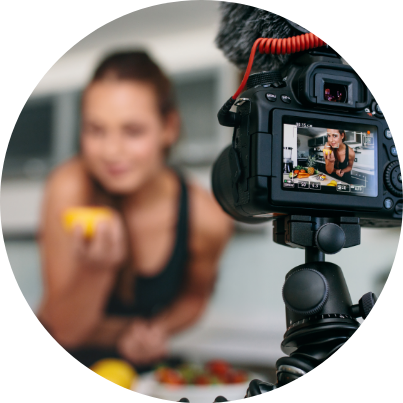 A woman being photographed while preparing food.