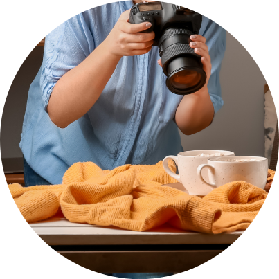 A photographer taking a photograph of some mugs.